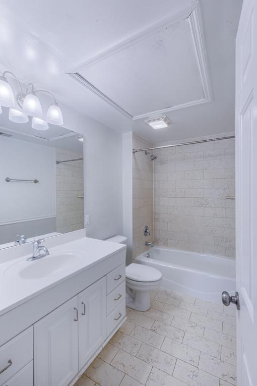 A white bathroom with a toilet, sink, and tub.