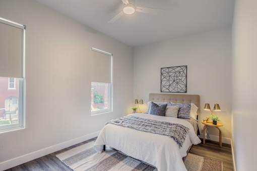 A bedroom with a large bed and a ceiling fan.
