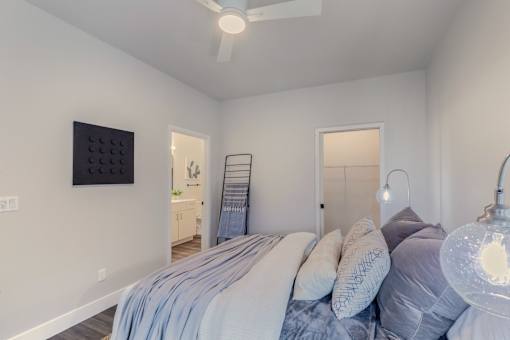 A bedroom with a bed and a ceiling fan.