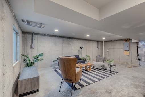 A room with concrete walls and a striped rug on the floor.