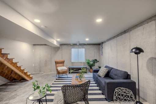 A living room with a couch, chairs, and a table.
