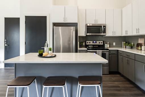 A modern kitchen with a large island and stools.