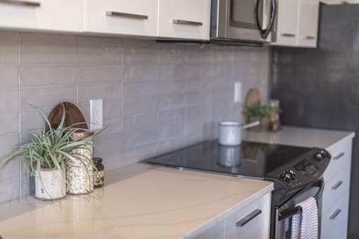 A kitchen with a black stove top oven and white cabinets.