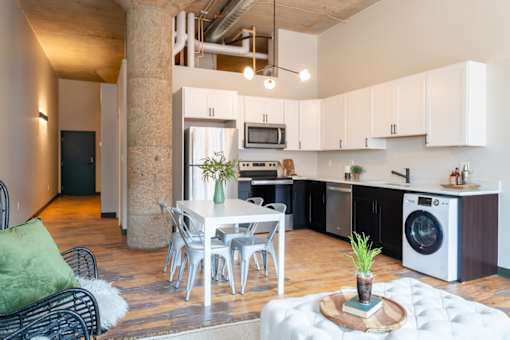 A modern kitchen with a dining table and chairs.