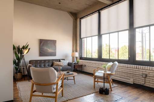 A living room with a couch, two chairs, and a table.