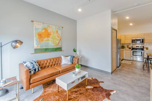 A living room with a couch, coffee table, and a map hanging on the wall.