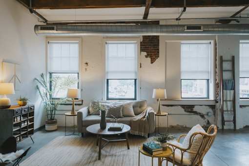 A living room with a couch, chairs, and a table with a book on it.