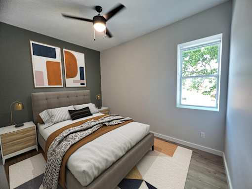 A bedroom with a bed, nightstand, and a ceiling fan.
