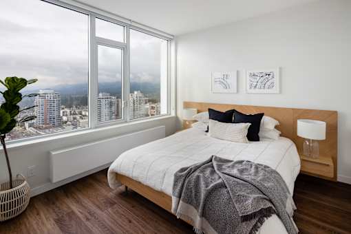 A bedroom with a large bed and a view of the city.