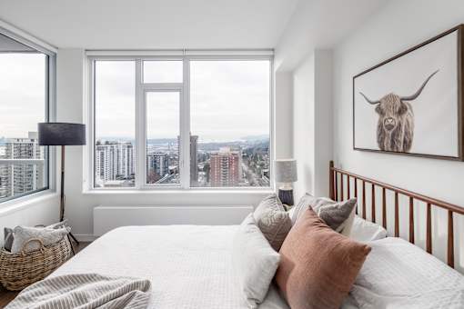A bedroom with a large bed and a painting of a bull on the wall.