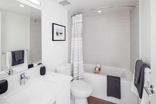 A white bathroom with a toilet, sink, and bathtub.