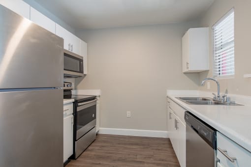 a kitchen with white cabinets and stainless steel appliances