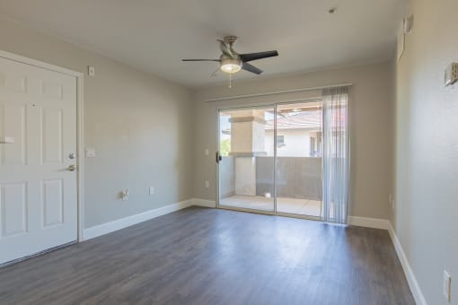 an empty living room with a ceiling fan