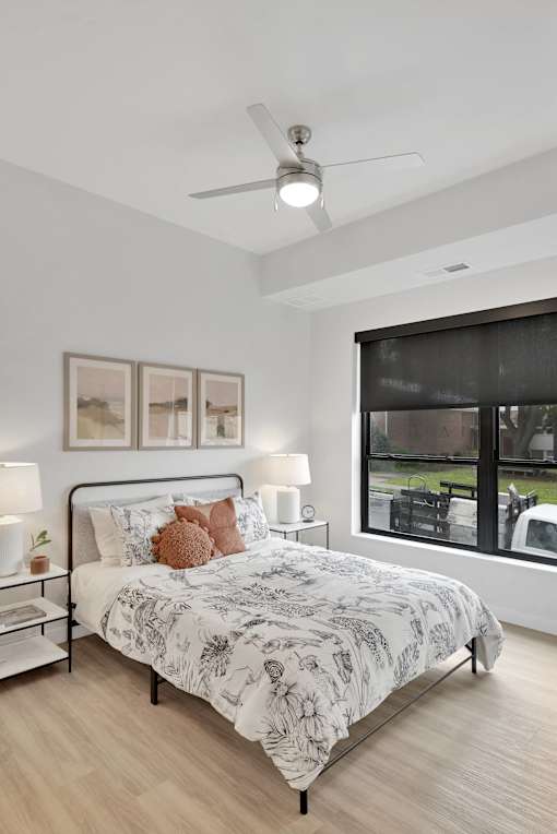 A bedroom with a large bed and a ceiling fan.
