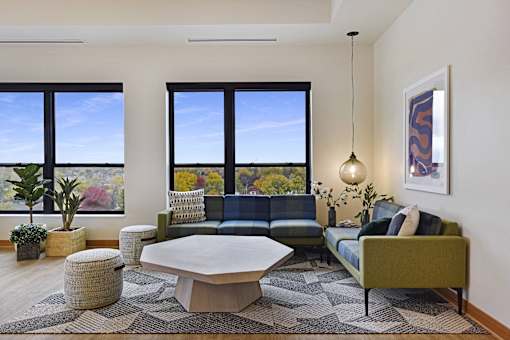 A living room with a couch, a table, and a large window.