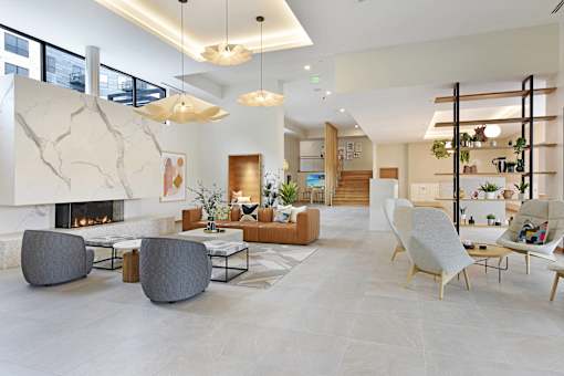 A modern living room with a fireplace and a variety of seating options.