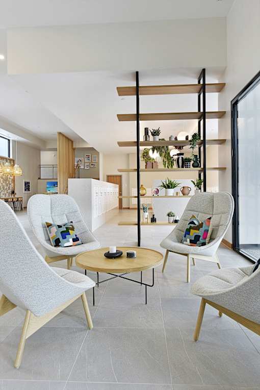 A modern living room with a white chair and a wooden table.