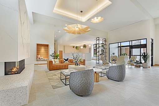 A modern living room with a fireplace and a large grey chair.