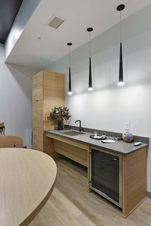 A modern kitchen with a wooden island and pendant lights.