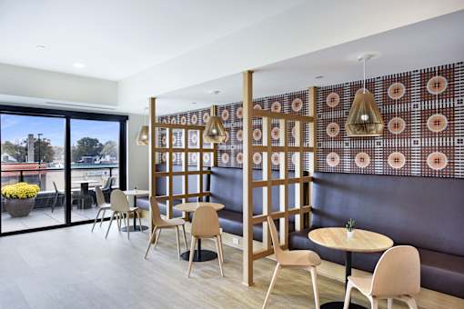 A room with a table and chairs and a wall with a pattern on it.