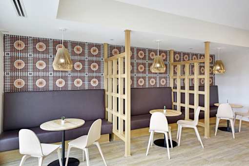A restaurant with a patterned wallpaper and wooden partition.