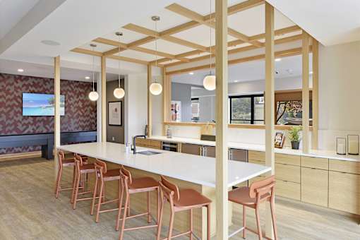 A kitchen with a long white table and chairs.