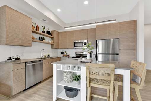 A modern kitchen with wooden cabinets and stainless steel appliances.