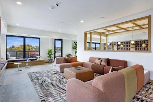 A living room with a large window and a view of trees outside.