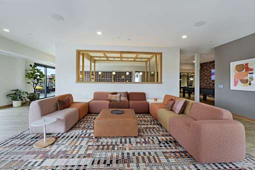 A living room with a large rug and a mirror on the wall.