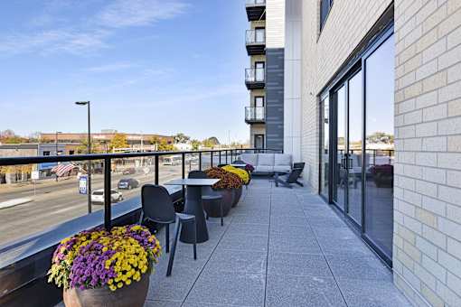 A balcony with a table and chairs overlooking a street.