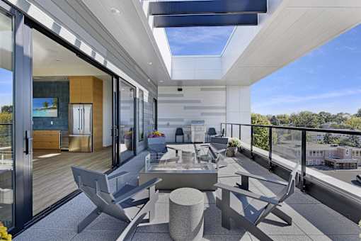 A modern balcony with a table and chairs overlooking a cityscape.