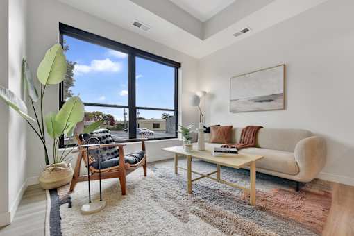 A living room with a couch, chair, and a large window.