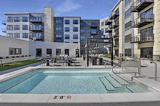 A swimming pool in front of a building with a height restriction sign.