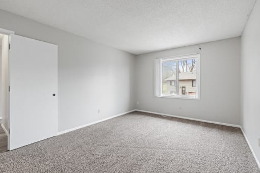 an empty room with carpet and a window