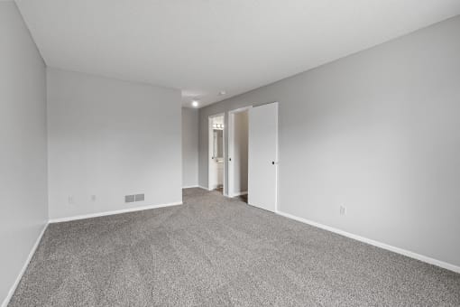 a spacious living room with carpet and white walls