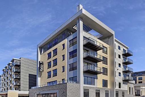 A modern building with a glass facade and balconies.