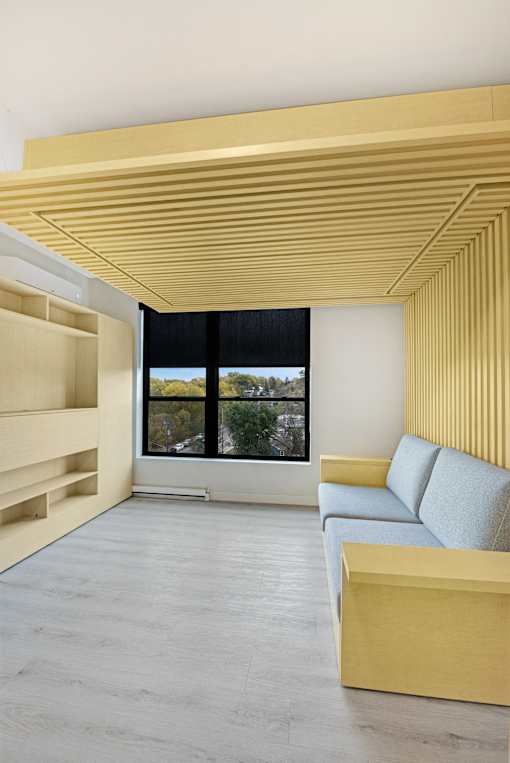 A modern living room with a yellow couch and a large window.