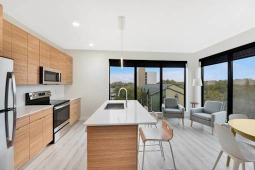 A modern kitchen with a large island and a view of the outdoors.