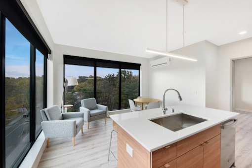 A modern kitchen with a large island and a view of the outdoors.