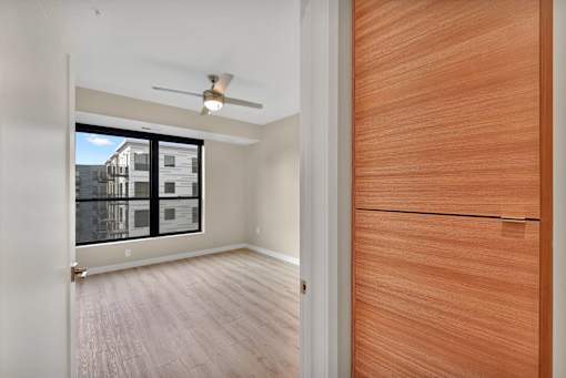 A room with a ceiling fan and a wooden door.