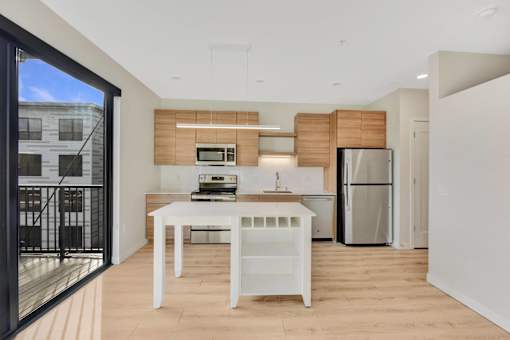 A modern kitchen with a white table and a refrigerator.