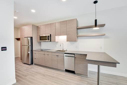A modern kitchen with a refrigerator, microwave, and a countertop.