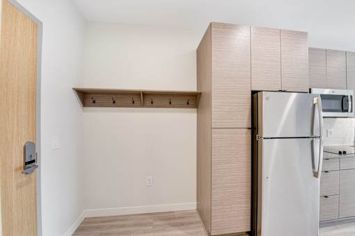 A kitchen with a refrigerator and a door.