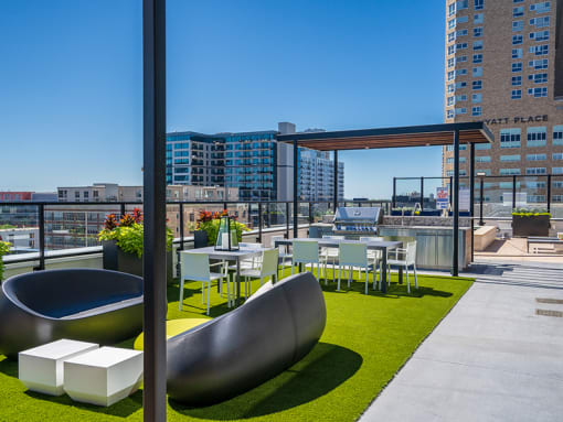 a roof top patio with tables and chairs and a view of the city