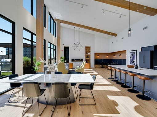 a large dining room with a table and chairs and a kitchen with a large window