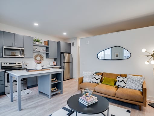 a living room with a couch and a kitchen with a table