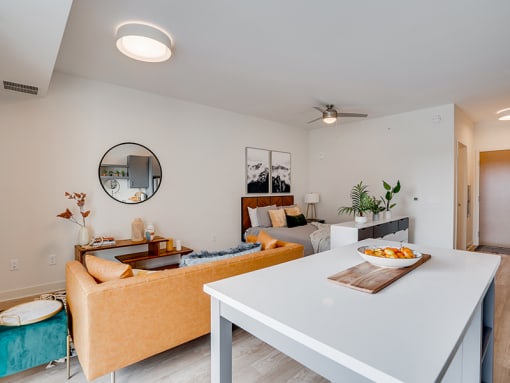 a living room with a white table with a bowl of fruit on it