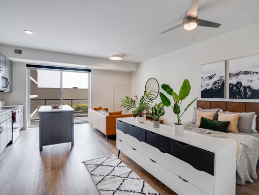 a bedroom and living room with a bed and a kitchen