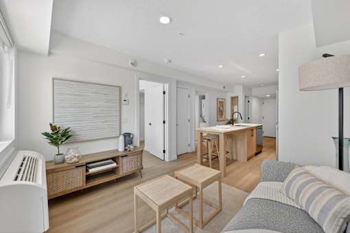 A living room with a grey couch and wooden furniture.