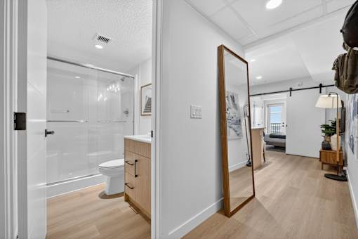 A bathroom with a toilet, sink, and mirror.